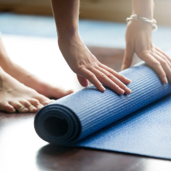 hands and feet unrolling yoga mat